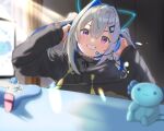  1girl adjusting_headphones amane_kanata animal_ear_headphones animal_ears axolotl black_hoodie blue_hair cat_ear_headphones chromatic_aberration colored_inner_hair commentary_request controller dongchuan fake_animal_ears game_controller grey_hair grin hair_between_eyes hair_ornament hairclip headphones headset highres hololive hood hoodie monitor multicolored_hair purple_eyes smile solo sunlight table two-tone_hair upao_(amane_kanata) upper_body virtual_youtuber 