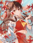  1girl absurdres ascot autumn autumn_leaves bare_shoulders blush bow brown_hair detached_sleeves hair_bow hair_tubes hakurei_reimu highres leaf long_hair maple_leaf open_mouth red_bow red_eyes red_skirt ribbon-trimmed_sleeves ribbon_trim sidelocks skirt solo touhou twitter_username uzmee white_sleeves wide_sleeves yellow_ascot 