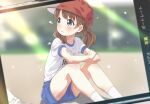  1girl arm_rest blue_eyes blue_shorts blurry blurry_background blush brown_hair cellphone commentary day eyelashes flat_chest hat highres idolmaster idolmaster_million_live! legs looking_at_another medium_hair name_tag on_floor outdoors parted_lips phone photo_(object) red_headwear shirt short_sleeves short_twintails shorts sitting smartphone socks solo suou_momoko thighs toma_(shinozaki) twintails white_shirt white_socks 