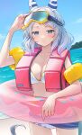  1girl absurdres alternate_costume animal_ears beach bikini breasts cleavage closed_mouth commentary cowboy_shot ear_covers goggles grey_eyes grey_hair highres hishi_miracle_(umamusume) horse_ears horse_girl horse_tail inflatable_armbands innertube life_vest looking_at_viewer medium_breasts medium_hair nabe_puyo ocean outdoors pink_innertube sand solo swimsuit tail umamusume water white_bikini 