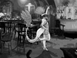  2023 absurd_res anthro black_and_white claws clothed clothing dated dinosaur dress dromaeosaurid elbow_feathers eyelashes feathered_dinosaur feathered_tail feathers female fingers flapper footwear hair hi_res high_heels i_wani_hug_that_gator inside long_tail looking_at_viewer looking_back looking_back_at_viewer lunara_(iwhtg) monochrome off_shoulder one_eye_closed photo_background photography_(artwork) reptile scalie sharp_teeth short_hair smile snout solo tail tail_tuft teeth theropod tuft velociraptor vkbird watermark wink winking_at_viewer 
