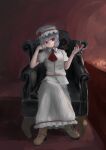  1girl absurdres armchair chair cup dark dark_room drinking_glass hand_on_own_face hat highres holding holding_cup looking_at_viewer mob_cap red_background remilia_scarlet shadow shinkopeishon solo touhou wall wine_glass 