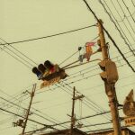  1girl brown_pants highres long_hair orange_shirt original pants pink_hair red_footwear shirt shoes sign sitting takashi_arima traffic_light wide_shot 