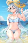  1girl absurdres aongumz bare_arms bare_shoulders beach bikini blue_bikini blue_eyes blue_hair blue_sky blush breasts cleavage cloud commentary day feet_out_of_frame furina_(genshin_impact) genshin_impact hand_on_own_chest hand_up hat highres long_hair looking_at_viewer navel ocean outdoors sitting sky solo stomach sun_hat swimsuit thighs very_long_hair water white_headwear 