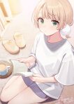  1girl architecture artist_name blonde_hair blunt_bangs blurry book bow casual commentary cup depth_of_field dot_nose expressionless from_above green_eyes grey_shorts hair_ornament holding holding_book indie_virtual_youtuber looking_at_viewer pom_pom_(clothes) pom_pom_hair_ornament sandals saucer shigure_ui shigure_ui_(vtuber) shirt short_ponytail short_sleeves shorts signature sitting solo symbol-only_commentary thighs virtual_youtuber wariza white_shirt yellow_bow 