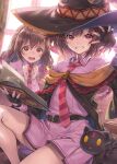  2girls belt black_gloves book brown_hair cape cat chomusuke clenched_hand collared_shirt day fingerless_gloves gloves hagure_keg hat highres holding holding_book indoors kono_subarashii_sekai_ni_shukufuku_wo! kono_subarashii_sekai_ni_shukufuku_wo!:_kurenai_densetsu long_hair long_sleeves looking_at_another looking_at_viewer megumin multiple_girls necktie open_mouth pink_shirt pink_skirt pleated_skirt red_eyes robe shirt sitting skirt smile teeth witch_hat yunyun_(konosuba) 