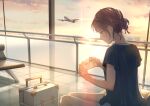  1girl absurdres aircraft airplane blue_shirt brown_hair closed_mouth cloud commentary_request feet_out_of_frame grey_eyes hair_bun highres holding indoors macaronk original pants profile shirt short_sleeves sitting sky smile suitcase sunset white_pants window 