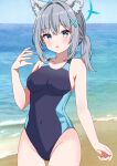  1girl absurdres animal_ear_fluff animal_ears beach black_one-piece_swimsuit blue_archive blue_eyes blue_sky breasts cloud competition_swimsuit covered_navel cross_hair_ornament day extra_ears grey_hair hair_ornament halo highres hiiragisensei horizon low_ponytail medium_breasts medium_hair mismatched_pupils multicolored_clothes multicolored_swimsuit ocean official_alternate_costume one-piece_swimsuit outdoors shiroko_(blue_archive) shiroko_(swimsuit)_(blue_archive) sky solo swimsuit wolf_ears 