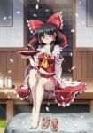 1girl alcohol barefoot black_hair bottle bow breasts cleavage commentary_request cup detached_sleeves frilled_bow frilled_hair_tubes frills hair_bow hair_tubes hakurei_reimu holding holding_cup legs long_hair looking_at_viewer lunamoon medium_breasts midriff navel off_shoulder red_bow sakazuki shoes shoes_removed sitting smile solo tabi touhou white_sleeves 