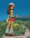  1girl black_wristband blue_sky brown_eyes brown_hair bulbasaur closed_mouth full_body grey_footwear highres holding leaf_(pokemon) light_frown looking_back loose_socks no_nose path pokemon pokemon_(creature) pokemon_(game) pokemon_frlg sky socks solo tessaku_ro vs_seeker white_headwear white_socks yellow_bag 