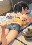  1girl barefoot black_hair breasts camisole commentary_request foot_out_of_frame foot_up from_behind gaki_kyonyuu grey_shorts handheld_game_console highres holding holding_handheld_game_console kaedeko_(kaedelic) large_breasts looking_at_viewer looking_back lying nintendo_switch on_stomach one-piece_tan oppai_loli red_eyes sasaki_kanna_(kaedeko) short_hair shorts soles solo tan tanlines toes twintails yellow_camisole 