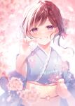  1girl amamine blue_kimono blurry blurry_background blurry_foreground blush brown_hair commentary_request depth_of_field flower grin holding holding_flower japanese_clothes kimono long_sleeves looking_at_viewer obi original pink_flower purple_eyes sash smile solo swept_bangs upper_body wide_sleeves 