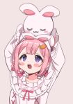  1girl :o animal_ears arms_up blush braided_hair_rings carrot_hair_ornament fake_animal_ears food-themed_hair_ornament grey_background hair_ornament hairband highres holding holding_stuffed_toy long_sleeves looking_up nightgown nijisanji object_on_head official_alternate_costume open_mouth pink_hair pink_nightgown pink_ribbon purple_eyes rabbit_ears ribbon saito_katuo simple_background solo stuffed_animal stuffed_rabbit stuffed_toy suo_sango suo_sango_(2nd_costume) upper_body virtual_youtuber white_hairband 
