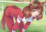 1girl animal_ears bent_over brown_eyes brown_hair commentary_request ear_covers ear_ribbon grass green_ribbon horse_ears horse_girl horse_tail jacket long_hair long_sleeves looking_at_viewer miri_(ago550421) nice_nature_(umamusume) outdoors red_track_suit revision ribbon short_hair solo sweat tail tracen_training_uniform track_jacket track_suit twintails umamusume unzipped zipper 