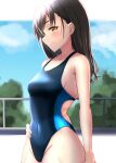  1girl absurdres black_hair blue_one-piece_swimsuit blue_sky brown_eyes cloud competition_swimsuit covered_navel cowboy_shot fence hand_on_own_hip highres idolmaster idolmaster_cinderella_girls jj_(zero_rin7) long_hair mole mole_under_eye one-piece_swimsuit profile sky smile solo sunazuka_akira swimsuit two-tone_swimsuit 