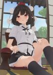  1girl black_hair commentary_request day expressionless feet_out_of_frame from_below hat highres indoors kanpa_(campagne_9) looking_at_viewer miniskirt parted_lips pom_pom_(clothes) red_eyes shameimaru_aya short_hair sitting skirt solo tatami thighs tokin_hat touhou window 