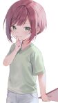  1girl closed_mouth commentary_request finger_to_mouth green_eyes green_shirt hand_up holding looking_at_viewer midorikawa_you mole mole_under_eye original pants red_hair shirt short_hair short_sleeves shushing sidelocks simple_background smile solo standing white_background white_pants 