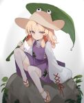  1girl absurdres animal_print blonde_hair brown_headwear closed_mouth commentary frog_print full_body hat highres holding holding_leaf kani_nyan knees_up leaf long_hair long_sleeves looking_at_viewer moriya_suwako purple_skirt purple_vest rock sandals sitting skirt smile solo thighhighs touhou turtleneck vest white_thighhighs wide_sleeves yellow_eyes 