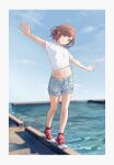  1girl absurdres balancing blue_sky border brown_eyes brown_hair commentary converse cross-laced_footwear determined full_body fuyutsuki11 hair_intakes high_tops highres light_blue_shorts looking_at_viewer navel ocean outstretched_arms project_sekai red_footwear shinonome_ena shirt shoes short_hair sidelocks sky smile smug sneakers solo t-shirt walking waves white_border white_shirt 
