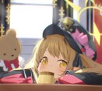  1girl absurdres blonde_hair blue_archive blurry blurry_background blush commentary food halo hat highres ibuki_(blue_archive) indoors looking_at_viewer patanda peaked_cap pointy_ears pudding solo stuffed_animal stuffed_toy teddy_bear twintails yellow_eyes 
