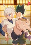  2boys absurdres carrying carrying_person child chinese_commentary closed_eyes commentary_request couple gon_freecss green_hair green_shorts heart highres hunter_x_hunter indoors killua_zoldyck long_sleeves male_child male_focus multiple_boys purple_eyes purple_footwear short_hair shorts sweat teeth white_hair yaoi zxanzai 