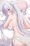  1girl 7nopi absurdres bikini blush breasts bright_pupils cinderella_(crystal_wave)_(nikke) cinderella_(nikke) closed_mouth commentary condom condom_wrapper goddess_of_victory:_nikke hair_over_one_eye highres indoors large_breasts long_hair looking_at_viewer looking_back lying median_furrow official_alternate_costume on_stomach pillow red_eyes sarong sideboob smile solo swimsuit twintails very_long_hair white_bikini white_hair white_pupils white_sarong yes-no_pillow 