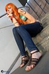  1girl bare_shoulders bikini_top breasts cosplay denim feet female highres jeans long_hair midriff nami nami_(cosplay) nami_(one_piece) nami_(one_piece)_(cosplay) one_piece orange_hair pants photo real sandals shoes sitting solo tattoo 