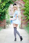  alice_(wonderland) alice_in_wonderland apron asian blonde_hair cosplay dress garden hair_ribbon high_heels highres long_hair looking_back nature photo real ribbon shoes striped striped_legwear striped_thighhighs thighhighs 