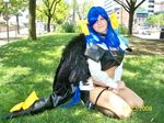  1girl arc_system_works blue_hair bow car cosplay dizzy female gear gears grass guilty_gear kneeling midriff motor_vehicle outdoors photo real smile tree van vehicle wings 