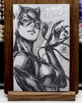  1girl art_tools_in_frame batman_(series) black_bodysuit black_mask bodysuit breasts cat_mask catsuit catwoman commentary cover_sketch dc_comics diamond_(gemstone) english_commentary fake_claws gem highres holding holding_gem large_breasts leather_suit looking_at_viewer marker_(medium) mask monochrome parted_lips photo_(medium) signature solo stanley_lau traditional_media whip 