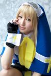  blonde_hair bridget bridget_(guilty_gear) cosplay cross fingerless_gloves gloves guilty_gear highres photo saya saya_(cosplayer) solo symbol 