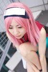  1girl asian bare_shoulders bike_shorts black_eyes blurry cosplay depth_of_field dress eyelashes haruno_sakura haruno_sakura_(cosplay) headband headdress highres kinako lips mole naruto outdoors photo pink_hair red_dress short_hair shorts sleeveless sleeveless_dress solo 