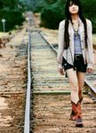  belt black_hair boots cowboy_boots female fukada_saki highres jewelry necklace open_clothes open_shirt photo railroad_tracks shirt shorts solo tank_top train_tracks vest walking 