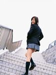  1girl asian blazer brown_hair cardigan cosplay dutch_angle highres knee_socks kneehighs long_hair looking_at_viewer looking_back miniskirt outdoors photo pleated_skirt school_uniform skirt socks solo sugimoto_yumi 