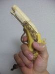  banana food fruit gun handgun highres holding photo pistol sculpture weapon y_yamaden 