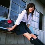  1girl asian brown_hair cosplay happy highres knee_socks kneehighs long_hair looking_at_viewer miniskirt photo pleated_skirt railroad_tracks school_bag school_uniform serafuku sitting skirt smile socks solo sugimoto_yumi train_station 