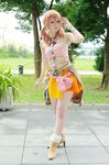  1girl belt boots bracelet cosplay female final_fantasy final_fantasy_xiii grass jewelry midriff navel necklace oerba_dia_vanille oerba_dia_vanille_(cosplay) outdoors pink_shirt shirt skirt solo standing tile tiles tree twintails 
