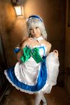  apron bed blue_dress bow cosplay dress female flower highres izayoi_sakuya lenfried photo ribbon silver_hair solo touhou 