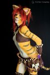  blue_eyes bodypaint clothed clothing cosplay ear_piercing feathers feline female hair leather mammal piercing real red_hair skimpy tiger tribal_clothing yuricocosplay yurikocosplay 