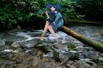  backpack bag blue_eyes blue_hair forest hair_bobbles hair_ornament hat kawashiro_nitori looking_at_viewer nature river rock shirt sitting skirt skirt_set sleeves_pushed_up soaking_feet solo touhou tree two_side_up water wtuw 