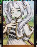  1girl 2024 art_tools_in_frame capelet closed_mouth commentary earrings elf english_commentary frieren grass green_eyes hand_on_own_chest highres holding holding_staff jewelry looking_at_viewer mage_staff marker_(medium) photo_(medium) pointy_ears shirt signature skirt smile solo sousou_no_frieren staff stanley_lau striped_clothes striped_shirt teardrop_earrings thick_eyebrows traditional_media twintails upper_body white_capelet white_hair white_shirt white_skirt 
