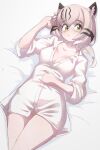  1girl animal_ears blush breasts cat_ears cat_girl commentary_request eurasian_lynx_(kemono_friends) extra_ears glasses green_eyes grey_hair highres kemono_friends large_breasts long_hair looking_at_viewer lowlandgorilla on_bed shirt simple_background solo white_shirt 