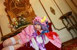  1girl asian cosplay couch crescent dress female garter_straps hat long_hair lying patchouli_knowledge photo purple_hair red_upholstery ribbon solo tenshi_myu thighhighs touhou 