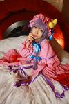  1girl asian bed blanket cosplay crescent dress female hat highres long_hair patchouli_knowledge photo pillow purple_hair solo tenshi_myu touhou 