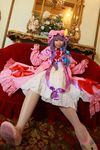  1girl asian bow carpet cosplay couch crescent dress female flower hat long_hair mirror mob_cap patchouli_knowledge photo purple_hair red_upholstery ribbon slippers solo tenshi_myu thighhighs touhou white_dress 