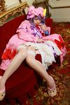  1girl asian cosplay couch crescent dress female garter_straps hat highres long_hair patchouli_knowledge photo purple_hair red_upholstery solo tenshi_myu thighhighs touhou 