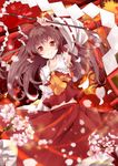  arm_up ascot brown_hair collarbone detached_sleeves flower gohei hair_tubes hakurei_reimu highres holding long_hair petals red_eyes sakura_ran smile solo touhou wind 