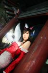  1girl ahri animal_ears bare_shoulders black_hair cosplay ekiholic facial_mark fox_ears fox_tail highres league_of_legends long_hair photo tail yellow_eyes 