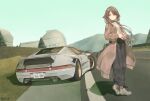  1girl baronilu belt_buckle breasts brown_coat brown_footwear brown_hair buckle building car coat collar commentary day exhaust_pipe full_body grass green_eyes green_pants hair_between_eyes hair_flaps highres interlocked_fingers license_plate long_hair medium_breasts motor_vehicle mountainous_horizon no_socks observatory own_hands_together pants parted_lips ribbon ridge_racer road shadow shirt signature solo spoiler_(automobile) sports_car standing tree trench_coat very_long_hair white_collar white_shirt 