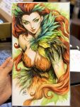  1girl absolute_batman absolute_dc artist's_hand_in_frame breasts claws cleavage closed_mouth commentary dc_comics english_commentary green_eyes hair_pulled_back highres large_breasts leaf leaf_clothing leaf_leotard long_hair looking_to_the_side makeup marker_(medium) photo_(medium) plant_clothing poison_ivy poison_ivy_(absolute_dc) red_hair signature solo stanley_lau traditional_media 